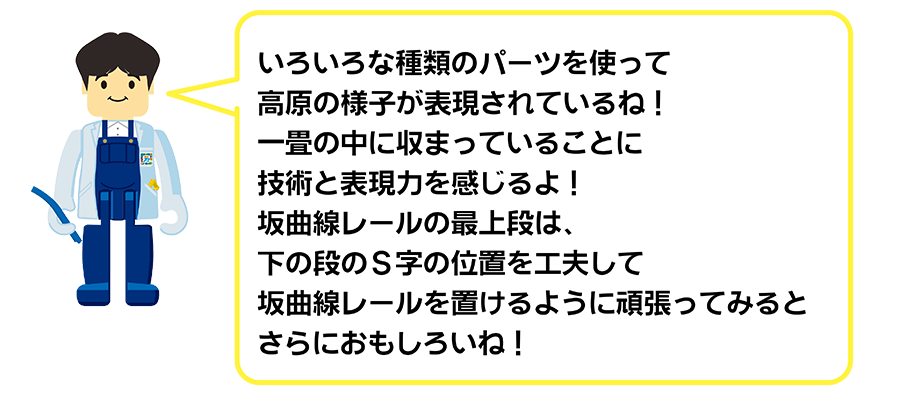 いろいろな種類のパーツを使って高原の様子が表現されているね！一畳の中に収まっていることに技術と表現力を感じるよ！坂曲線レールの最上段は、下の段のS字の位置を工夫して坂曲線レールを置けるように頑張ってみるとさらにおもしろいね！